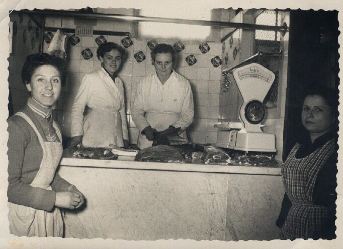 Fotografia antiga de la parada al Mercat Municipal de Calella de Can Vives amb les nostres avies darrere del taulell
